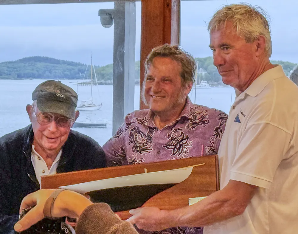 Presentation of half model  of Viola to (l ) David Bicks, chairman of Castine Classic Yacht Regatta and Fred Doane (r), Commodore of Castine Yacht Club by Kostia Belkin (center) owner of Viola